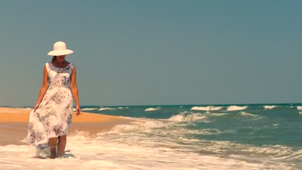 ロマンチックな女性のドレスと帽子海岸 徒歩でビーチします — ストック動画