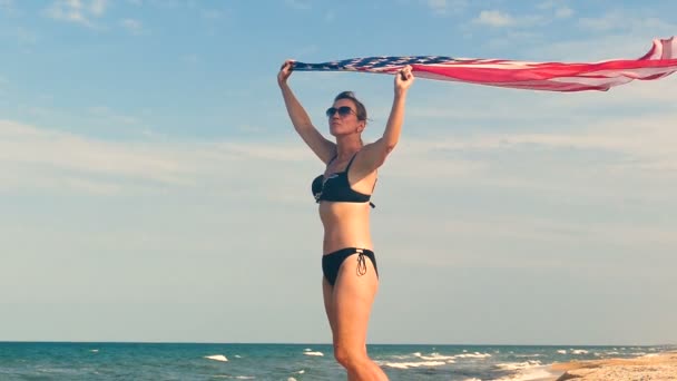 Patriotische Ernste Frau Mit Amerikanischer Flagge Der Nähe Des Meeres — Stockvideo