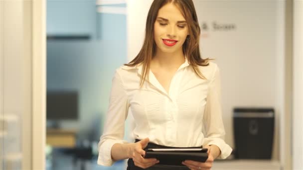 かなりビジネスの女性は オフィスのタブレットで作業に行きます 安定したショット — ストック動画