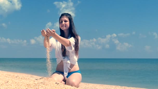 女の子のティーンエイ ジャーの手 スローモーションから注ぐ海岸砂 — ストック動画
