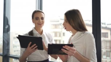 4. genç ve yetişkin iş kadını ofiste tablet ile tartışın. Sürekli çekim