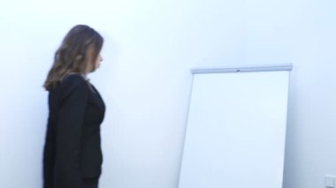       bir şey göstermek 4 k. seksi genç iş kadını flipchart kullanarak bilgileri,.