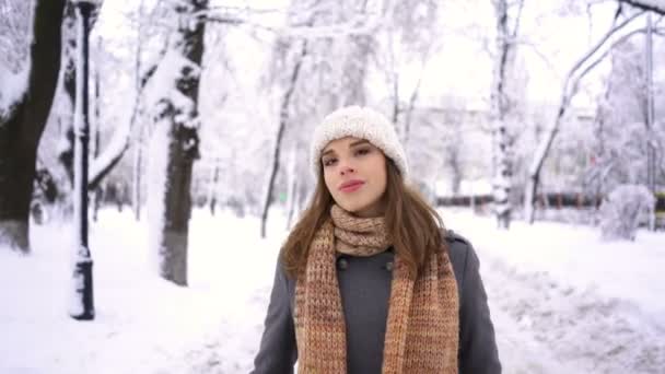 穿着白帽子走在冬季城市公园的年轻女子 稳定的拍摄 — 图库视频影像