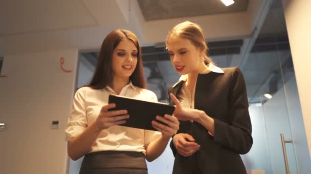 Zwei Junge Lächelnde Geschäftsfrauen Diskutieren Mit Tablet Stehershot Büroarbeitsteam — Stockvideo