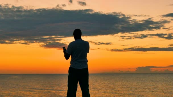 Homme Avec Smartphone Contre Coucher Lever Soleil Marin — Video