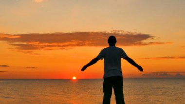 4. erkek deniz günbatımı veya gündoğumu karşı derin derin düşünür. Ellerini yukarı kaldır