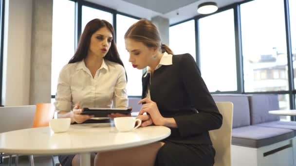 Twee Jonge Zakelijke Vrouwen Drinken Koffie Kantoor Kijk Tablet Talk — Stockvideo