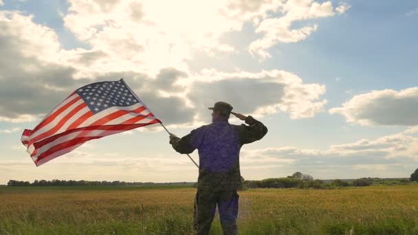 Żołnierz Salute Amerykańską Flagą Przeciwko Błękitnym Niebem Scena Wolnego Ruchu — Wideo stockowe