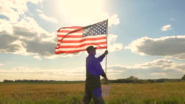 Στρατιώτης Στέκεται Στο Πεδίο Και Κρατάει Την Αμερικάνικη Σημαία Εναντίον — Αρχείο Βίντεο