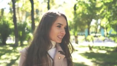   4 k. genç çekici gülümseyen kadın yürüyüş güneşli Şehir Parkı içinde hayat sahiptir.