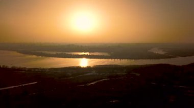 4k anten. Gece batımı gölünün üzerinde güneş ışığı yansıması ile göl veya nehir