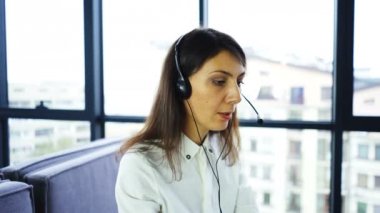 4k. Office çağrı merkezi çalışması. Kadın operatör cevap istemci, laptop kullanarak