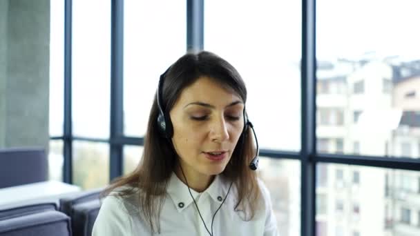 コールセンターの仕事 女性オペレータ応答クライアント ラップトップを使用して スライダーショット — ストック動画