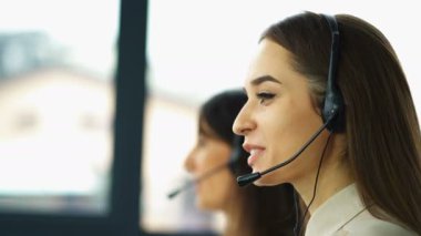 4k. Office çağrı merkezi çalışması. İki genç kadın operatörler müşteri cevap 