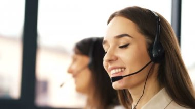 4k. Office çağrı merkezi çalışması. İki genç gülümseyen kadın operatörler müşteri cevap 