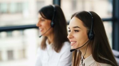 4k. Iki genç gülümseyen kadın operatörleri müşteri cevap. Office çağrı merkezi çalışması