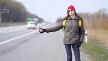                          Genç güzel kadın otostop, parmak yukarı, seyahat ekibi 