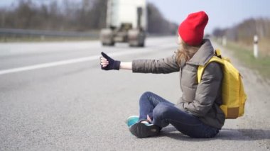                          Genç güzel kadın otostop, parmak yukarı. Yol kenarında otur, kaymak atışı