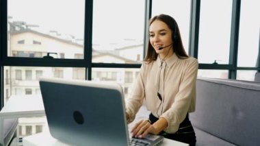 4k. Çağrı merkezi işi. Kulaklıkları kadın operatörü ofiste müşteri cevap