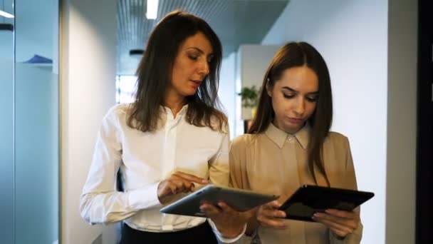 Δύο Νεαρές Ελκυστικές Επιχειρηματικές Γυναίκες Συζητούν Tablet Στο Γραφείο Σταθερή — Αρχείο Βίντεο