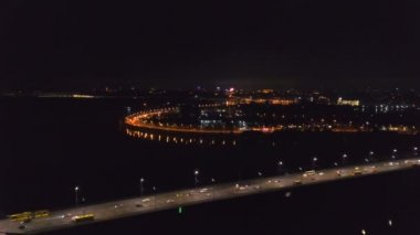   4k Hava. Şehir yolu, yol. Nehir üzerinde gece şehir trafiği