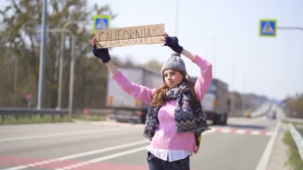 Junge Hübsche Frau Trampt Stoppendes Auto Mit Plakat Kalifornien — Stockvideo