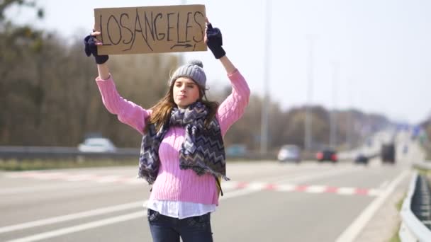 Jovem Mulher Carona Ficar Com Cartaz Los Angeles Equipa Viagem — Vídeo de Stock