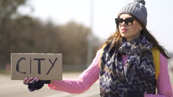 Привлекательная Молодая Женщина Автостопом Пытается Получить Город Плакатом — стоковое видео