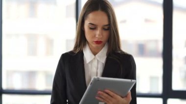 4. Çekici genç iş kadını ofiste tablet ile yürümek . Sabit atış