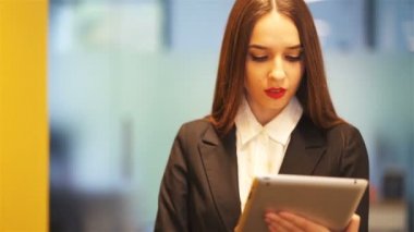 4. Ciddi genç iş kadını ofiste tablet ile yürümek . Sabit atış