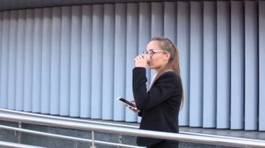 İyi haber. Akıllı telefon ve kahve ile gülümseyen genç iş kadını . Sabit atış