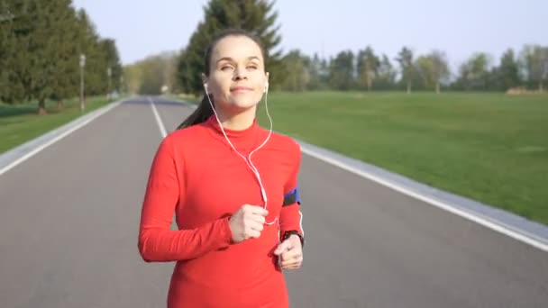 Happy Corredor Mujer Correr Camino Vacío Ropa Roja Escuchar Música — Vídeo de stock
