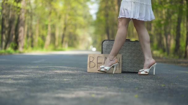 ポスタービーチとレトロなスーツケースの近くにハイヒールの靴の女性の足 — ストック動画
