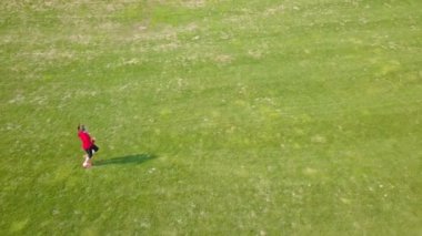 4k. Hava. Kadın fitness koşucusu yeşil alanda çalıştırın. Kamera üstü