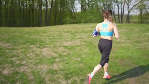 Vrouw Runner Run Groene Veld Luisteren Muziek Koptelefoon Stabiel Schot — Stockvideo