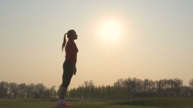 4k. Sportif kadın siluet spor egzersizleri yapmak, gündoğumuna karşı vücut ısınma