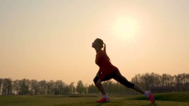 健身女性剪影做体育锻炼 身体热身对日出 — 图库视频影像