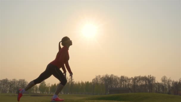运动女性剪影做体育锻炼 身体热身对日出 — 图库视频影像