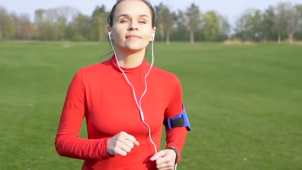 緑のフィールドで走る幸せな大人の女性ランナー スローモーション — ストック動画