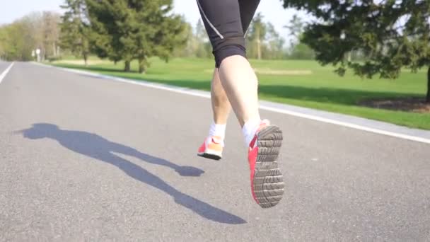 スローモーション フィットネス女子ランナーが路上を走る 背面図 — ストック動画