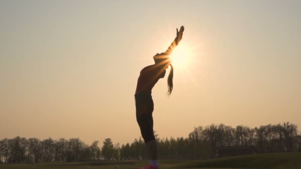 苗条的女人做运动练习 身体热身对抗日出 慢动作 — 图库视频影像