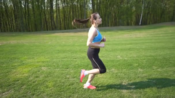 Slow Motion Fitness Woman Runner Run Green Field Steady Shot — Stock Video