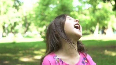 4k. Mutlu kız çocuk parlak kamera, şehir parkı gülüyor. Portre, sabit çekim