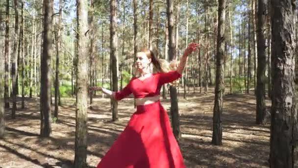 Danse contemporaine moderne improvisation. Compétence ballerine femme en robe rouge dansant dans le paysage forestier d'été . 