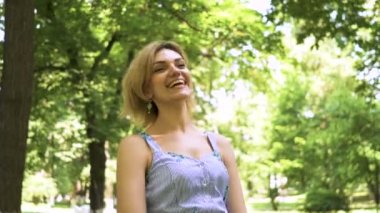   4k. güzel beyaz kadın bahar şehir parkında yürümek. Sabit yüz portre