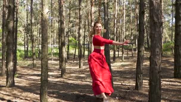 L'improvisation danseuse. Ballerine habile femme en robe rouge dansant en forêt. Ralenti, tir sur trépied 