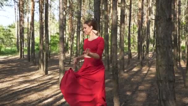Contemporary dancer improvisation. Skill ballerina woman in red dress dancing in forest landscape. Slow motion