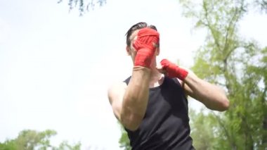 4. gölge ile kas adam Boxer eğitim. Kamera darbeler, yüz yakın. Şehir Parkı açık boks sabit atış