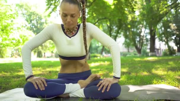 4K夏の公園の女性は ヨガの瞑想演習を行います ベリーダンス 胃の使用 スライダーショット ゆっくりとした動き — ストック動画