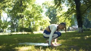 4k. Yoga asana. Yaz şehir parkında Kadın meditasyon egzersizleri yapmak , sürgü atış